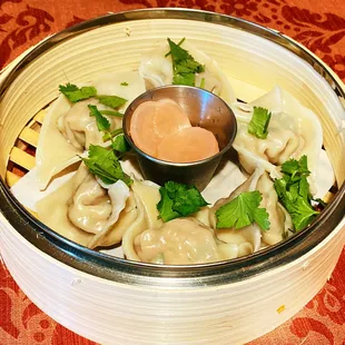 Boiled dumplings w/ pork and chive filling served w/ house pickles and dumpling sauce, garnished w/ cilantro