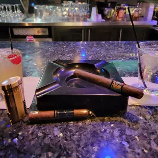 Cosmo Knights bar with cigars, drink, and water.