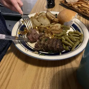 Filet of beef and fried potatoes with peppers and onions
