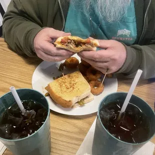 Stacked steak sandwich with side order of onion rings.