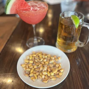 a glass of watermelon and a plate of nuts