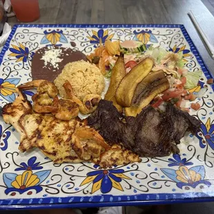 Steak, Chicken, and Shrimp with rice and beans, salad and fried plantains.