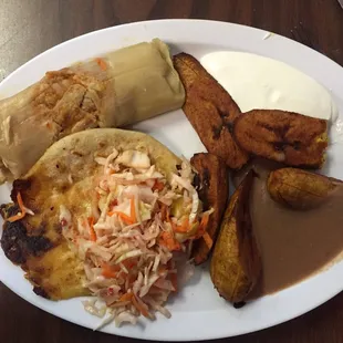 Delicious combination plate of chicken tamal, chicharron pupusa, and platanos that I already munched on.