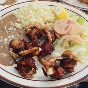 Camarones Rellenos - Bacon Wrapped Shrimp w/ Cheese. Rice, beans, &amp; salad as sides. This plate does come with homemade corn tortillas.