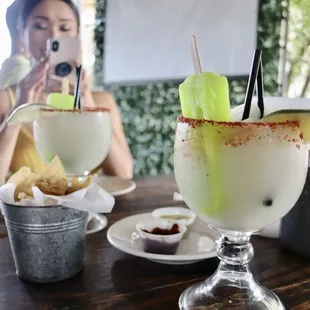 a woman taking a picture of a margarita