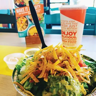 a bowl of mexican food and a drink