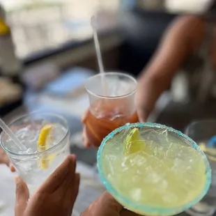 two people holding drinks and a margarita