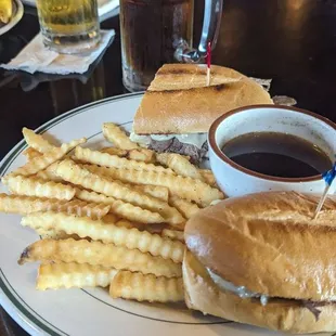a plate with a sandwich, french fries and a cup of coffee