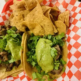 2 Carne Asada Taco Tuesday with cilantro, guacamole, and no onion requested and fresh restaurant tortilla chips