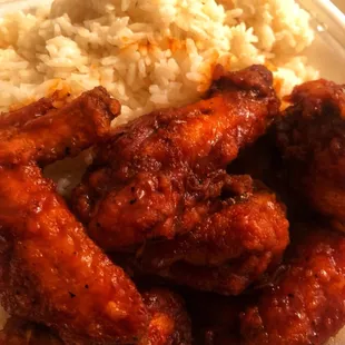 chicken wings and rice on a styrofoam plate