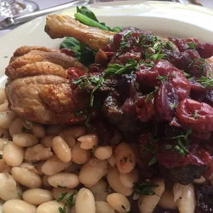 French Country Duck - roasted duck confit &amp; duck breast, topped with cherry sauce, served with seasoned white beans and fresh spinach