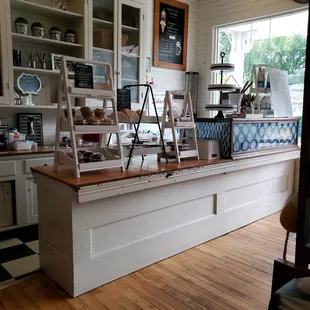 a kitchen with white cabinets and wood floors