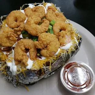 Stuffed Baked Potato with fried shrimp and a side of BBQ sauce
