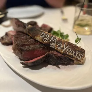 a plate of steak and a glass of wine