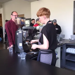 a woman making a cup of coffee