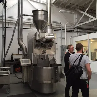 a man standing in front of a coffee grinder