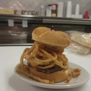 a burger with onion rings on a plate