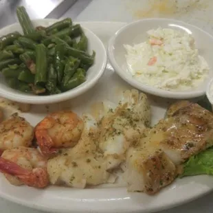a plate of food with shrimp, green beans, and coleslaw