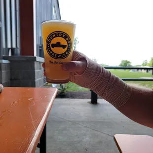 Pint of Delusions of Grandeur NEIPA and the open space surrounding the Covered Patio.