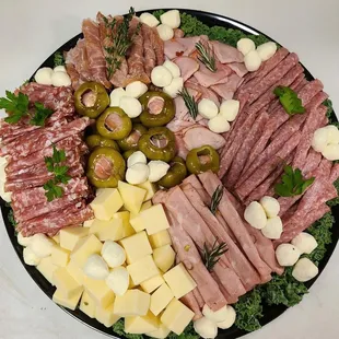 a platter of meat, cheese, and olives