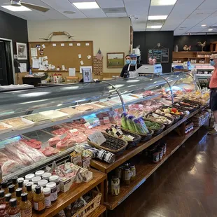 a man standing in front of a display of meat