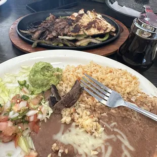 Fajita Mix. Chicken and Fajita w/ Flour tortillas ,Guacamole, pico, Rice and beans.  EVERYTHING SIZZLING STILL!!!!