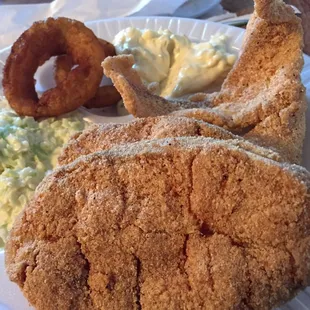 a plate of fried fish, coleslaw and onion rings