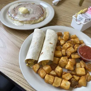 Flat cinnamon roll pancake and breakfast tacos with breakfast potatoes.