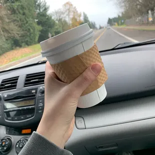 a hand holding a cup of coffee