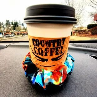 a cup of coffee on the dashboard of a car