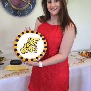 a woman in a red dress holding a cake