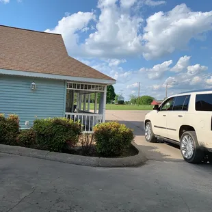 a white suv parked in front of a blue building