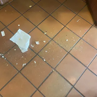 Trash on the floor in between the register and the counter were we had to pay