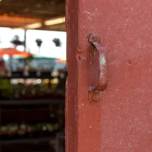 a rusted door handle on a red door