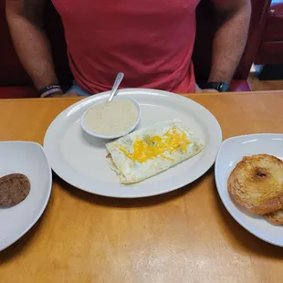 Egg white omelet with a buttered croissant,  sausage, and grits