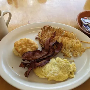 a breakfast of eggs, hash browns, bacon and waffles