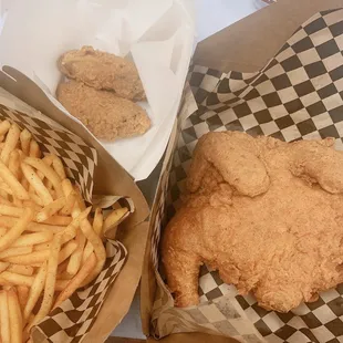 a basket of french fries and a basket of fried chicken