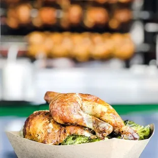 a basket of chicken and broccoli