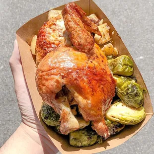 a hand holding a tray of food