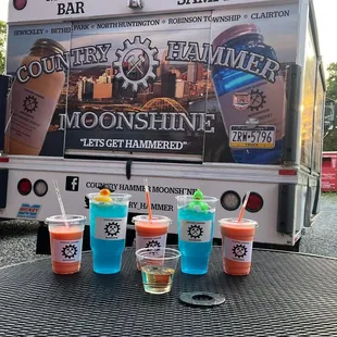 four drinks on a table in front of a truck