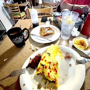 Western Omelette, 1/2 a hash brown patty, grits &amp; French toast. Coffee &amp; water. That&apos;s dots of ketchup on top of the omelette.