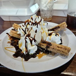 a banana split with whipped cream and chocolate syrup