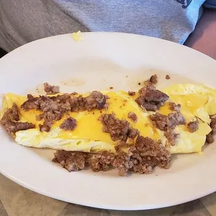 a plate of pancakes with sausage and cheese