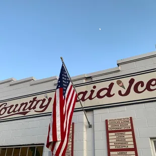 a large american flag in front of a building