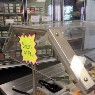 a display case with salads in it