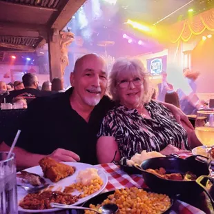 a man and a woman sitting at a table full of food