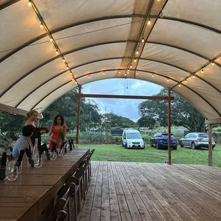 a long wooden table with chairs under a canopy