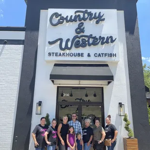 a group of people standing in front of a restaurant