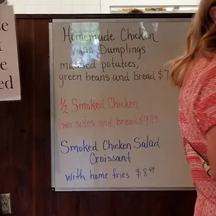 a woman standing in front of a menu