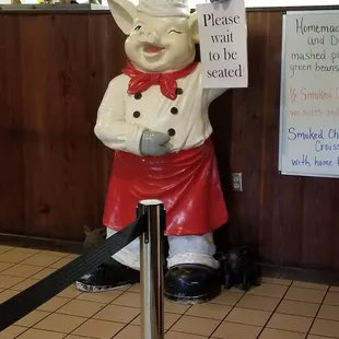 a statue of a chef holding a sign